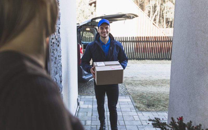 cheerful-delivery-man-carrying-box-customer cheerful-delivery-man-carrying-box-customer